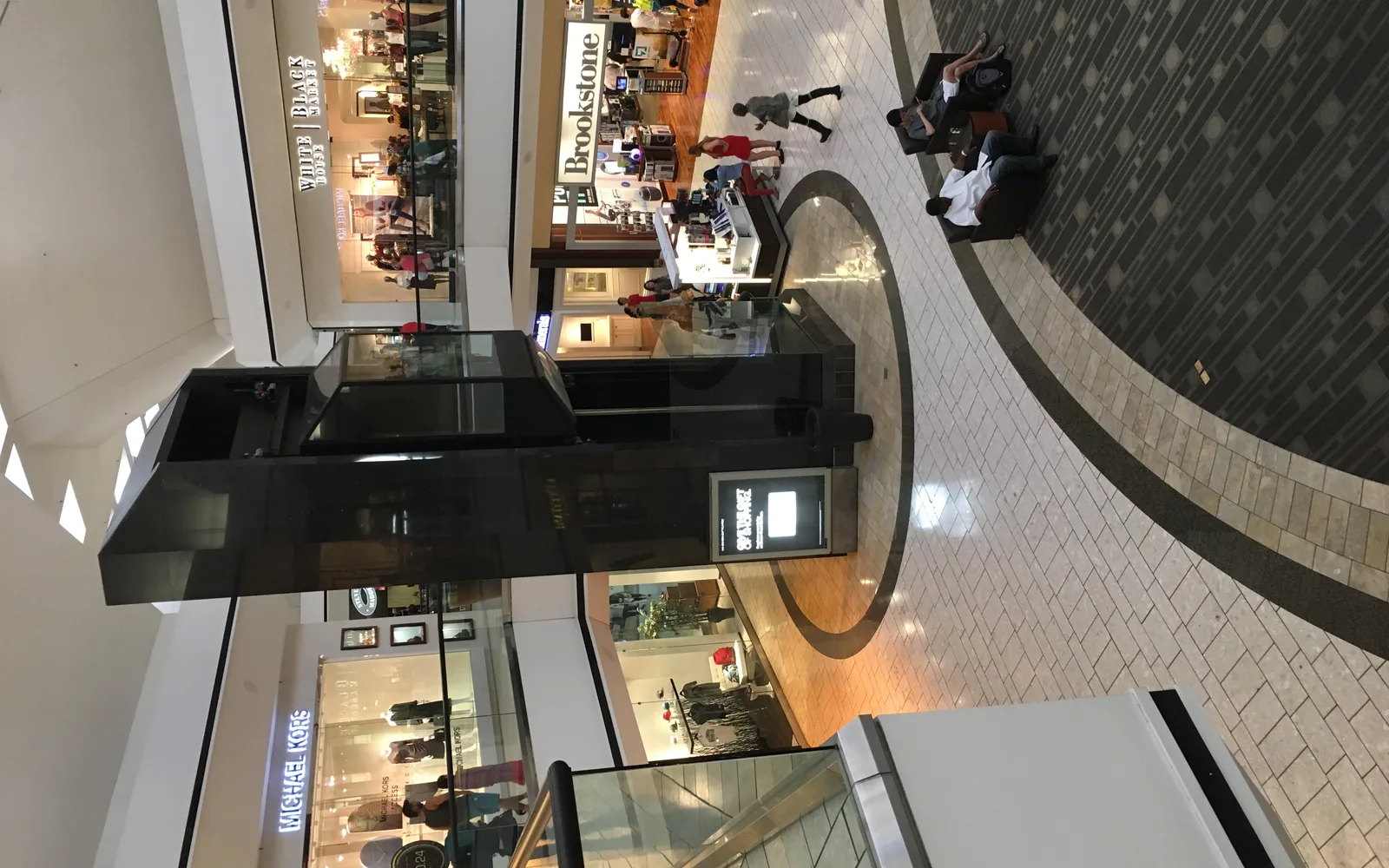 Modern shopping mall courtyard with decorative planters and architectural features